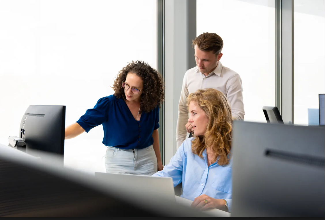 Colleagues gathered around a computer